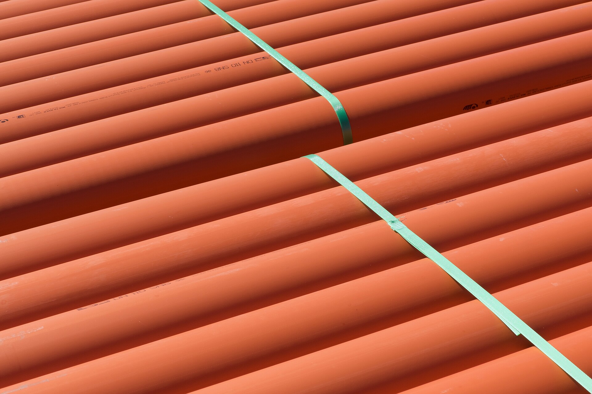 Các ống nhựa PVC màu cam được xếp tại công trường